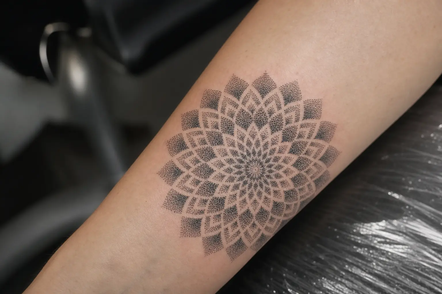 Dotwork mandala op de onderarm, opgebouwd uit duizenden losse punten.