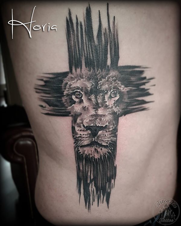 ArtCastleTattoo Tattoo ArtiestHoria Realistic lion face in cross tattoo black n grey in side Black n Grey