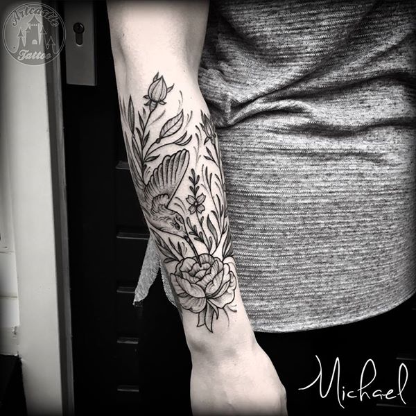 ArtCastleTattoo Tattoo ArtiestMichael Hummingbird and flowers tattoo on lower arm light black n grey Blackwork