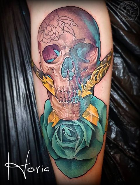 ArtCastleTattoo Tattoo ArtiestPrive Horia Skull with two ornate gold daggers turquoise rose semi realism semi neo traditional full color tattoo Color